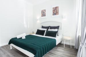 a bedroom with a bed with a green and white blanket at Central 1BD Apartment by Hostlovers in Kaunas