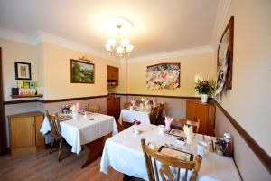 a dining room with two tables and a chandelier at Corrigans Shore House in Enniskillen
