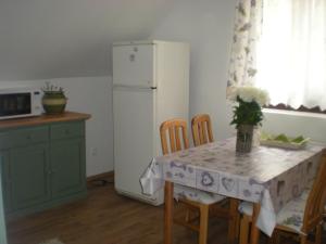 a kitchen with a table and a white refrigerator at Levendulas Apartman in Balatonalmádi