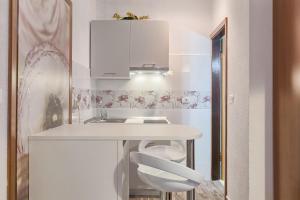 a small kitchen with a white counter and a sink at Vila Milla in Premantura +120 photos