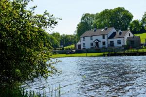 una casa a orillas de un río con una casa en Corrigans Shore House en Enniskillen