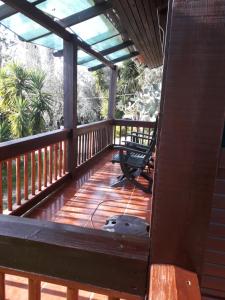 a deck with a chair and a dog sitting on it at Redondo Lodges in Junceira