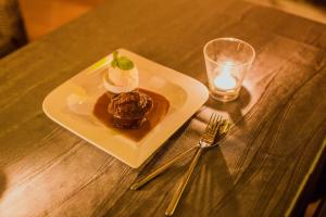 a plate of dessert on a table with a glass of water at Victory Road Villas in Phong Nha