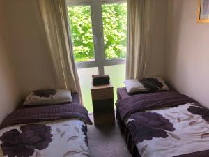 two beds in a room with a window at Glancys Accomadation in Carrick on Shannon