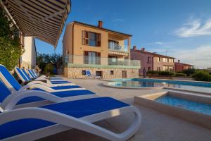 a row of lounge chairs next to a swimming pool at Villa Nicole in Banjole