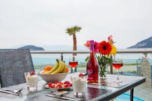 a table with a bowl of fruit and glasses of wine at Rent House Karavi in Iraklitsa