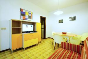 una camera con tavolo, TV e sala da pranzo di Villetta Lagomare a Lido di Spina