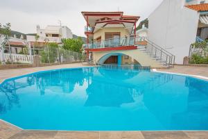 a large blue swimming pool in front of a house at Rent House Karavi in Iraklitsa