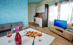 a room with a table with wine glasses and fruit on it at Rent House Karavi in Iraklitsa