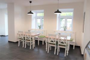 uma sala de jantar com mesa, cadeiras e janelas em JM Apartments em Hardegg