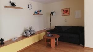 sala de estar con sofá negro y mesa en Ferienwohnung Jo Secco, en Bruttig-Fankel