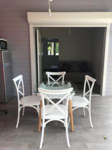eine Terrasse mit einem Tisch, Stühlen und einem Sofa in der Unterkunft BUNGALOW LOLOTTE ET DOM in Sainte-Anne