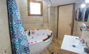a bathroom with a bath tub and a sink at Rent House Karavi in Iraklitsa
