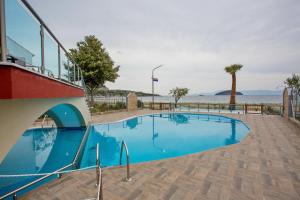 a swimming pool with blue water in front of the ocean at Rent House Karavi in Iraklitsa
