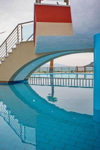 a swimming pool with a bridge over water at Rent House Karavi in Iraklitsa