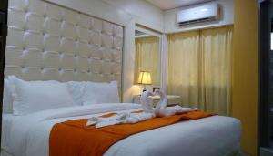 um quarto de hotel com uma cama com dois cisnes em Setrac Orange em Nova Bombaim