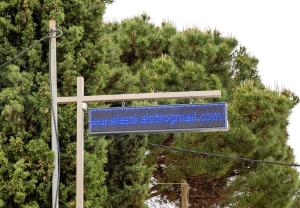 a blue sign on a pole next to a tree at Rent House Karavi in Iraklitsa