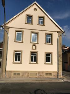 een wit huis met veel ramen aan een straat bij Gramschatzer Straße 7 in Güntersleben