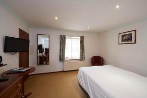 The Priory Hotel tesisinde bir odada yatak veya yataklar