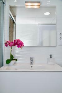 a bathroom sink with a vase with a flower on it at Luxury 12th Floor Beachfront in El Campello