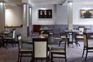 a restaurant with tables and chairs in a room at The Priory Hotel in Beauly