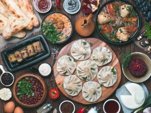 a table topped with plates of food and other foods at Olimpo Guest House in Akhaltsikhe
