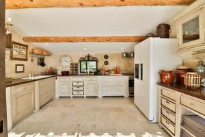 a kitchen with white cabinets and a white refrigerator at Le Mas Les Eydins in Bonnieux