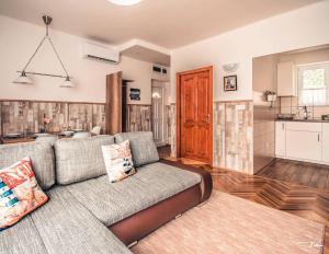 a living room with a couch and a kitchen at Sirály Apartman Fonyód in Fonyód