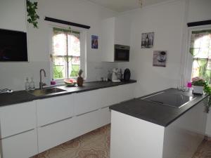 a kitchen with white cabinets and black counter tops at Lifestyle Balaton in Siófok