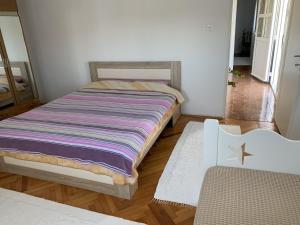 a small bedroom with a bed with a striped blanket at Draskovic's House in Bar