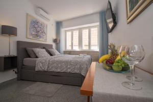 1 dormitorio con 1 cama y un plato de fruta en una mesa en Apartments Galerija, en Korčula