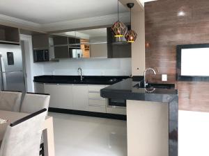 a kitchen with a sink and a counter top at Apartamento 602 Edifício Thermas Palace in Piratuba