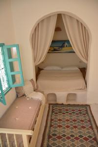 a small room with two beds and a window at Dar Lily in Erriadh