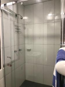 um chuveiro com uma porta de vidro na casa de banho em Tezza Apartment two blocks from the American Embassy em Lima