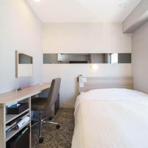 a hotel room with a bed and a desk at Super Hotel Shonan Fujisawaeki Minamiguchi in Fujisawa