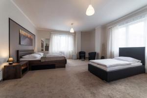 - une chambre avec 2 lits, un bureau et une fenêtre dans l'établissement Penzion Homér Slaný, à Slaný