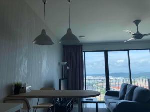 Una sala de estar con una mesa y una gran ventana. en Vivian's Studio Trefoil Setia Alam, en Shah Alam