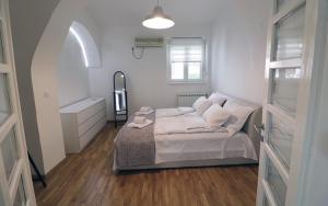 a white bedroom with a bed and a sink at Apartman Tina in Novi Sad