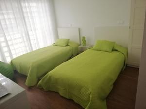 dos camas sentadas una al lado de la otra en un dormitorio en Casa do Engenho en Caldas de São Jorge