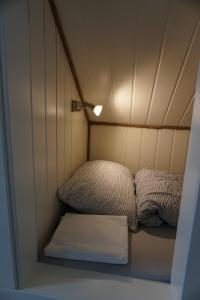 a small room with two beds and a light at Varanger Fisherman's Shed in Varangerbotn