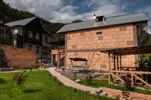 un edificio de ladrillo con un banco en un patio en Guest House VIP, en Borjomi