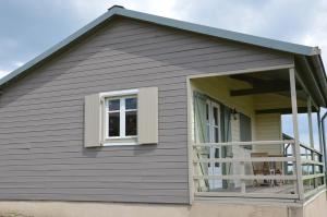 a house with a large window and a balcony at Le Chardonneret du Domaine du Moulin 15 in Étables