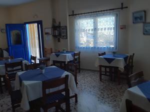 jadalnia ze stołami i krzesłami oraz oknem w obiekcie Villa Firostefani w mieście Firostefani