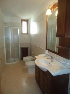 a bathroom with a sink and a toilet and a shower at VILLA GARDA HOUSE 42 in Marina di Mancaversa