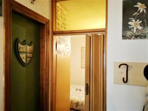 eine offene Tür zu einem Zimmer mit einem Schlafzimmer in der Unterkunft Piccolo Igloo in Falcade