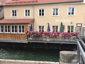 a building with flowers and umbrellas on a dock at Gästehaus Sarker in Landsberg am Lech