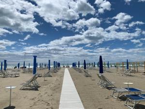 a row of chairs and umbrellas on a beach at Casa Celeste in Viareggio