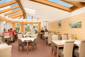 ein Restaurant mit Tischen, Stühlen und Tischen in der Unterkunft Ferienhotel Bernstein in Trassenheide