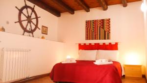 a bedroom with a red bed with towels on it at Villa Magarà in Cefalù
