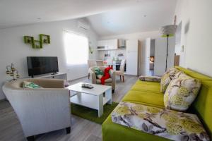 ein Wohnzimmer mit einem grünen Sofa und einem Tisch in der Unterkunft Studio Apartman Sky in Rovinj